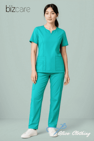 Woman in turquoise medical scrubs with short sleeves and large front pockets, standing against a pale background; bizcare logo top-left and Alice Clothing watermark bottom-right.