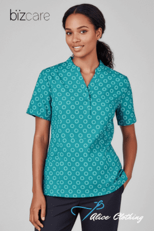 Female model wearing a teal short-sleeve polo with a white circular pattern; brand logos appear in the corners.