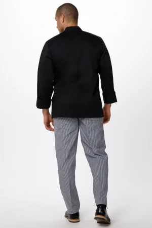 Man seen from behind wearing a black jacket with rolled sleeves and gray checkered pants, standing against a white backdrop