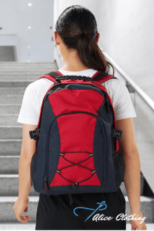 Back view of a person wearing a red and navy backpack while ascending stairs; white t-shirt visible from behind.