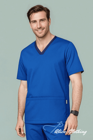 Smiling man wearing cobalt blue V-neck medical scrubs, standing against a light background with his hands at his sides.
