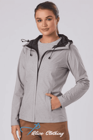 Female model wearing a light gray zip-up jacket with a black-lined hood, standing with one hand in her pocket.