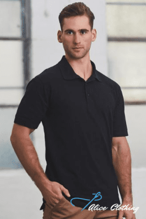 Male model wearing a black polo shirt, standing with one hand in pocket in an industrial-style setting (brand: Alice Clothing).