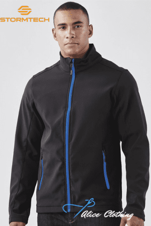 Male model wearing a black Stormtech jacket with blue zipper and blue-trimmed pockets; studio product photo with branding in the corner.