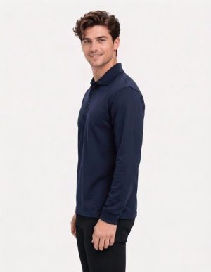 Man in a navy long-sleeve polo shirt standing in profile against a light background, smiling slightly.