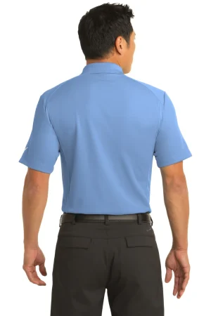 Back view of a person wearing a light blue polo shirt and dark pants, facing away from the camera.