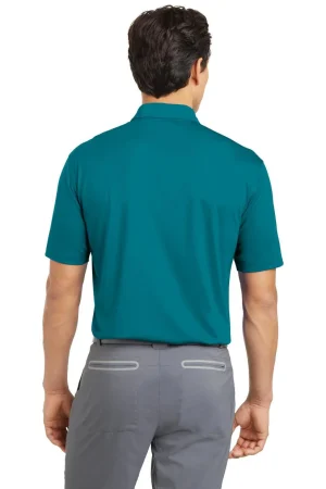 Back view of a man wearing a teal polo shirt and gray pants.