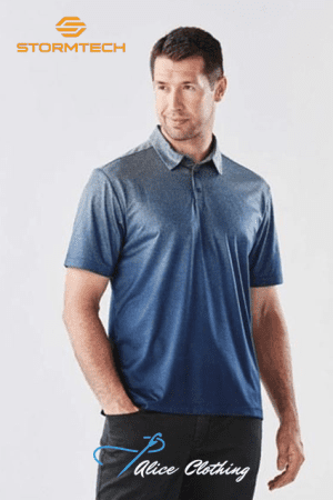 Man modeling a blue polo shirt with a gradient, standing with one hand in his pocket; Stormtech logo top left and Alice Clothing watermark at bottom.