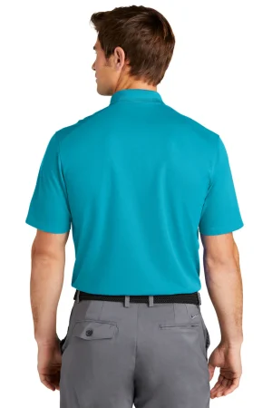 Back view of a man wearing a turquoise polo shirt and gray pants with a black belt, facing away from the camera.