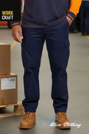 Warehouse worker in navy cargo pants and tan boots, standing with hands in pockets (logos: Work Craft, Alice Clothing)