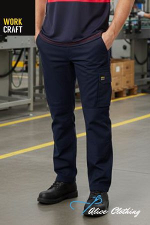 Person wearing navy work pants with a side pocket in an industrial workshop; logos 'WORK CRAFT' and 'Alice Clothing' visible.