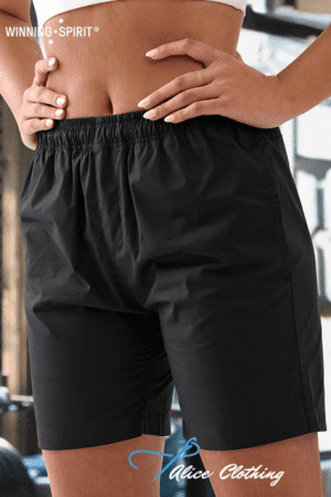 Close-up of a person wearing black elastic-waist athletic shorts from the waist to mid-thigh; branding logos are visible on the image.