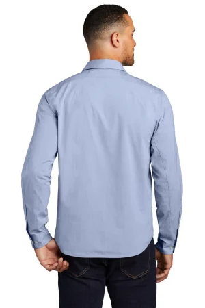 Back view of a man wearing a light blue button-down shirt and dark jeans, standing against a white background.