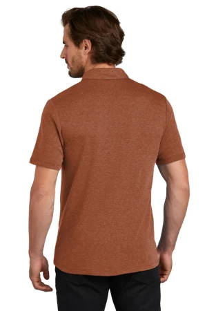 Back view of a man wearing a rust-brown short-sleeve polo shirt, standing in black pants.