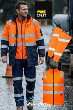 Male construction worker in a bright orange hi‑vis jacket and navy pants with reflective stripes, standing on a wet street; an orange hi‑vis vest lies on the ground beside him; WORK CRAFT logo above.