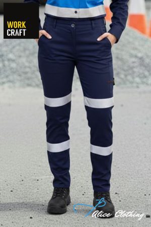 Person wearing navy work trousers with reflective bands at knees and shins, standing on a construction site.