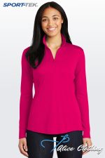 Portrait of a woman smiling in a bright pink long-sleeve pullover, standing against a light gradient background; SPORT-TEK logo in the top-left corner and 'Alice Clothing' graphic on dark jeans.