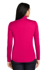 Back view of a woman wearing a bright pink long-sleeve top and dark jeans