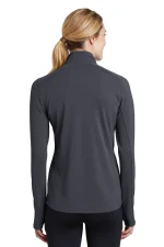 Back view of a woman wearing a dark gray textured athletic jacket with a high collar and a ponytail visible.