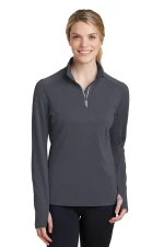 Smiling woman wearing a dark gray quarter-zip athletic top with a zip neckline.