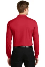 Man wearing a red long-sleeve shirt tucked into black dress pants with a black belt, viewed from the back.