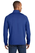 Back view of a man wearing a blue zip-up jacket and jeans, highlighting the jacket's fit and color.